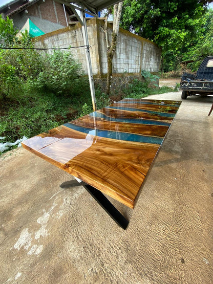 Modern dining table with electric blue resin stream and matte black steel legs
